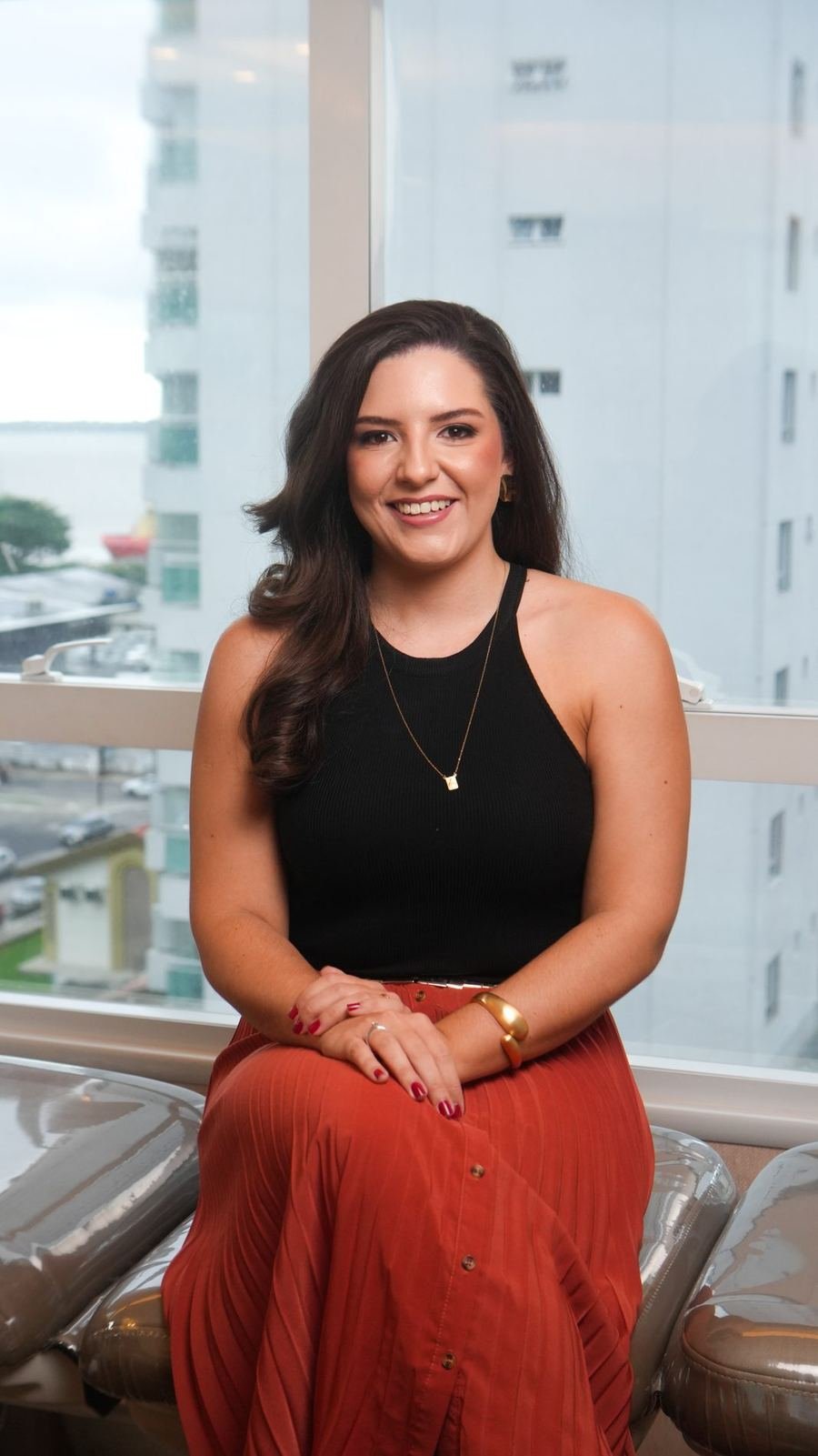 Dra. Mariana Amanajás sentada junto à janela do consultório